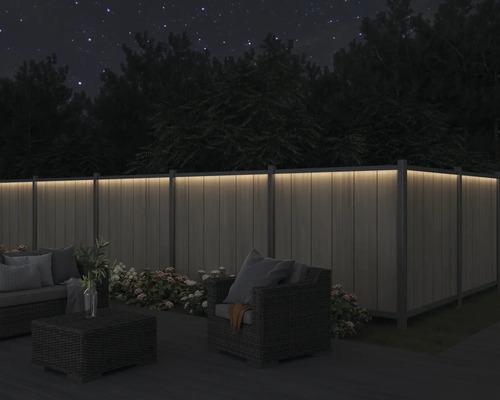 Beleuchteter Zaun im Garten bei Nacht mit Sitzgruppe