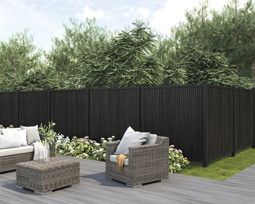 Gartenszene mit dunklem Sichtschutzzaun, Lounge-Möbeln und Bepflanzung