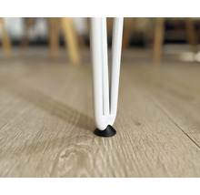 Detailaufnahme eines weißen Tischbeins mit Bodenschoner auf einem Holzboden.