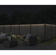 Szene mit beleuchtetem Gartenzaun, Sitzgruppe und Bepflanzung bei Nacht