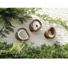 Drei verschiedene Vogelhäuser aus Keramik sind an einer Mauer befestigt.