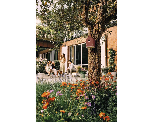 Szene im Garten mit Menschen, Pflanzen und einem Vogelhaus am Baum