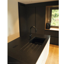 Küchenszene mit Spüle, Armatur und Küchengeräten vor dem Fenster