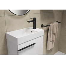 Waschtisch mit Armatur, Handtuchhalter und Handtuch im Badezimmer