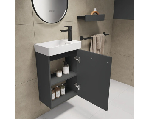 Badezimmer mit Waschbeckenunterschrank, Armatur, Spiegel, Ablage und Handtuchhalter