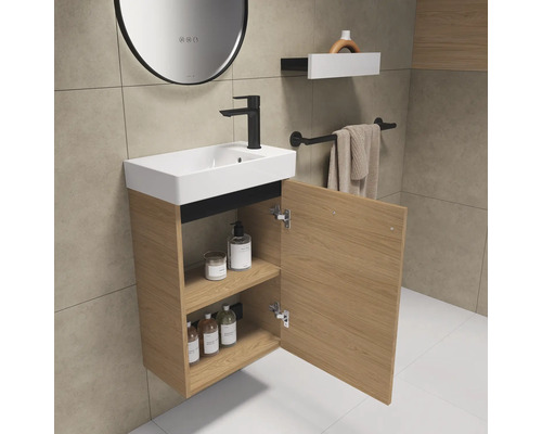 Badezimmer mit Waschbecken, Unterschrank mit geöffneter Tür, Armatur und Ablagefläche