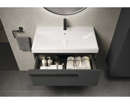 Waschtisch mit offenem Schubfach, Handtüchern und Kosmetikartikeln im modernen Badezimmer