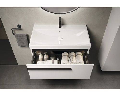 Modernes Badezimmer mit weißem Waschtischunterschrank, offenem Schubfach und Handtüchern