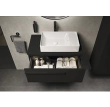 Waschbeckenunterschrank mit geöffneter Schublade, darin Badutensilien und Handtücher