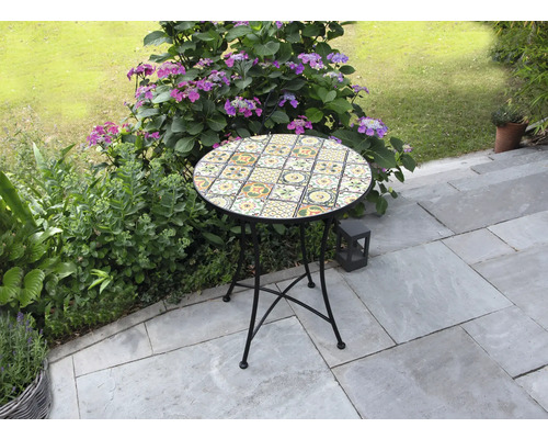Runder Gartentisch mit Mosaikmuster auf einer Terrasse
