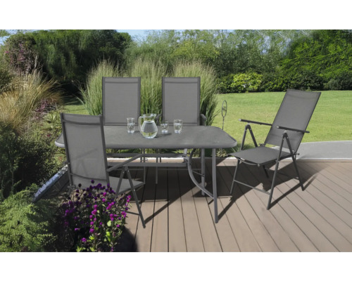 Gartenszene mit Esstisch, Stühlen, Gläsern und Wasserkrug auf einer Terrasse