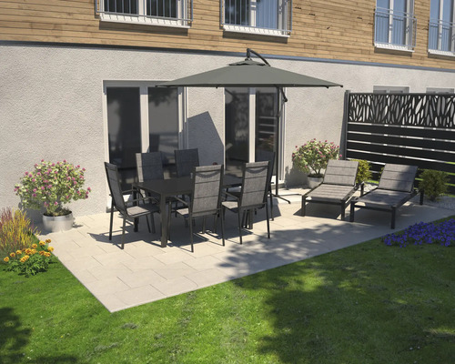 Gartenszene mit Esstisch, Stühlen, Sonnenschirm und Liegestühlen auf einer Terrasse.