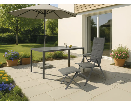 Gartenszene mit Sonnenschirm, Tisch, Stuhl und Fußhocker auf einer Terrasse