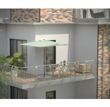 Balkon mit Sonnenschirm, Tisch, Stühlen und Pflanzen für eine entspannte Atmosphäre im Freien