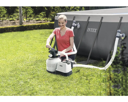 Frau bedient Intex Sandfilteranlage neben Pool