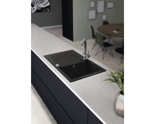Schwarzes Spülbecken mit Wasserhahn auf einer Küchentheke.