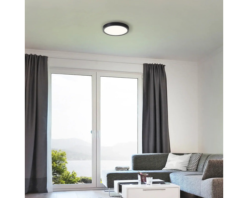 Wohnzimmer mit Deckenleuchte und großen Fenstern