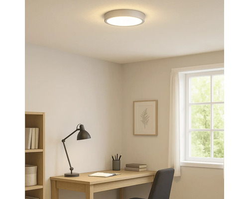 Beleuchtetes Arbeitszimmer mit Deckenleuchte, Schreibtisch und Fenster.