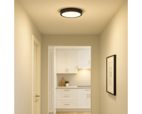 Flur mit runder Deckenleuchte und Blick in eine Küche mit weißen Möbeln