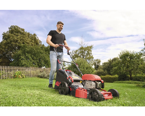 Mann mäht Rasen mit einem AL-KO Rasenmäher im Garten.