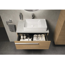 Badezimmer mit Waschbecken, offenem Schubladenschrank und Handtüchern