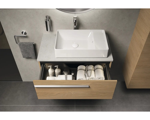 Badezimmer mit Waschbecken, offenem Schubladenschrank und Handtüchern
