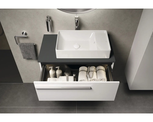 Badezimmer mit Waschtisch, Waschbecken und offenem Schubfach mit Handtüchern und Pflegeprodukten