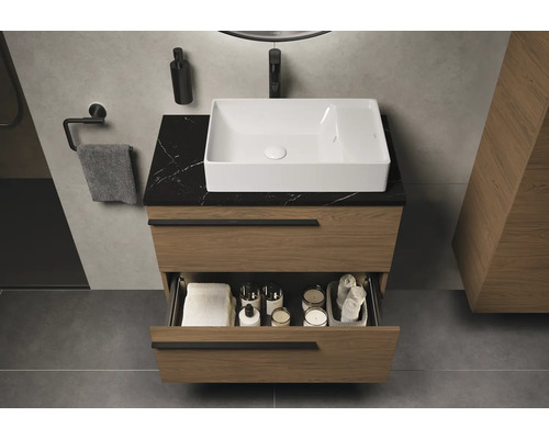 Badezimmer mit Waschbecken, Unterschrank mit Schublade, Armatur und Accessoires.