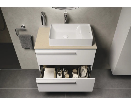 Modernes Badezimmer mit Waschbecken auf Unterschrank mit offener Schublade und Badutensilien