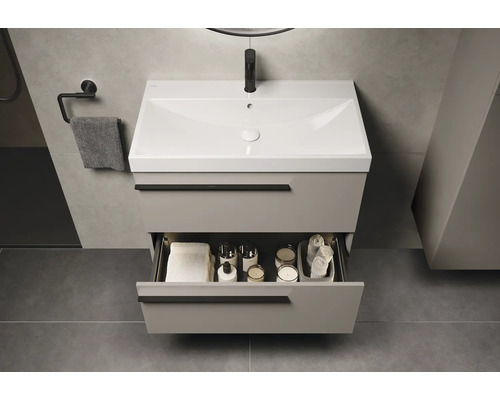 Waschtischunterschrank mit offenem Schubfach, Handtuch und Badartikeln im Badezimmer.