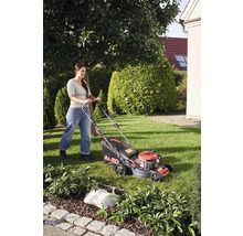 Frau mäht Rasen mit Rasenmäher von AL-KO im Garten.