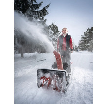 Mann benutzt eine Schneefräse, um Schnee zu räumen.