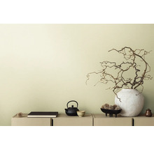 Dekorative Szene mit Teekanne, Buch und Zweigen in Vase auf einem Sideboard