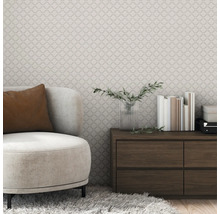 Wohnzimmer mit gemusterter Tapete, Sessel und Holzkommode