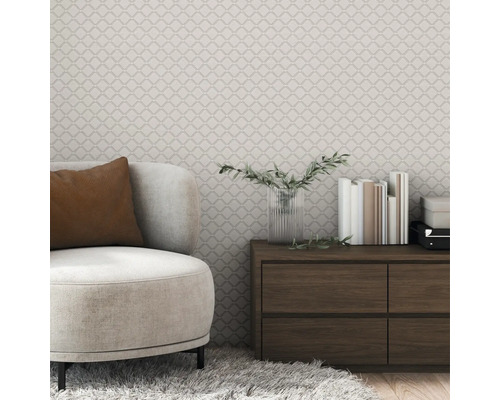 Wohnzimmer mit gemusterter Tapete, Sessel und Holzkommode