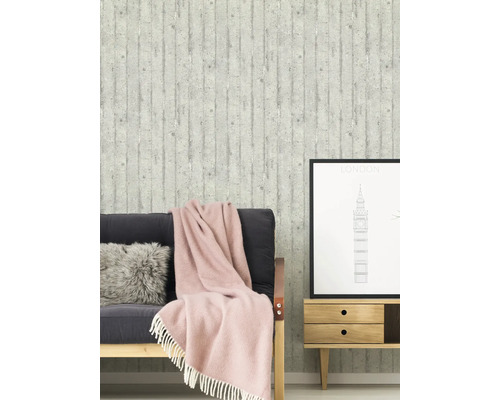 Wohnzimmer mit Betonstruktur Tapete, Sofa, Kissen, Decke und Beistelltisch mit London Bild