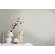 Dekorative Szene mit Kerzen, Vase, Zweigen, Uhr und Skulptur auf einem Tisch.