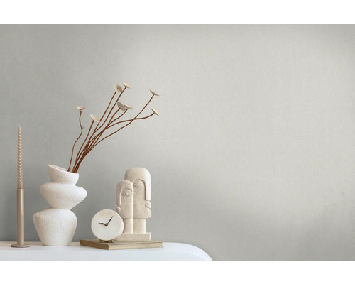 Dekorative Szene mit Kerzen, Vase, Zweigen, Uhr und Skulptur auf einem Tisch.