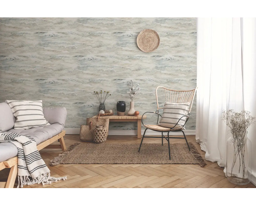 Wohnzimmer mit gemusterter Tapete, Sofa und Sessel auf einem Teppich