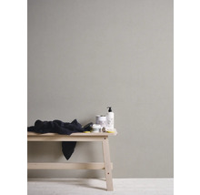 Wand mit Kosmetikprodukten und einem Tuch auf einem Holzbänkchen