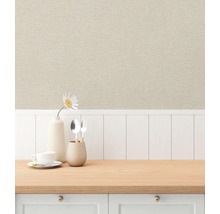 Szene mit beiger Vliestapete in Leinenoptik über einer weißen Holzpaneelwand