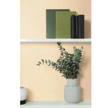 Dekoratives Regal mit Büchern und Eukalyptus in Vase.