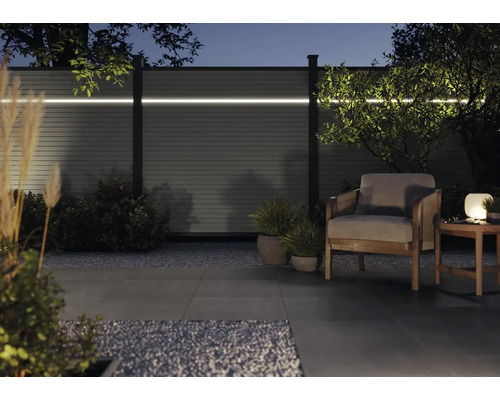 Gartenszene mit Sichtschutzzaun mit Beleuchtung, Sessel und Beistelltisch