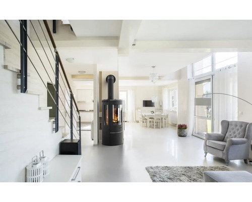 Heller Wohnraum mit Treppe, Kaminofen, Esstisch und Sessel