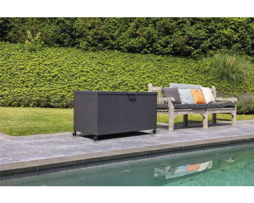 Szene mit einer Aufbewahrungsbox mit Rollen neben einer Gartenbank auf einer Terrasse am Pool