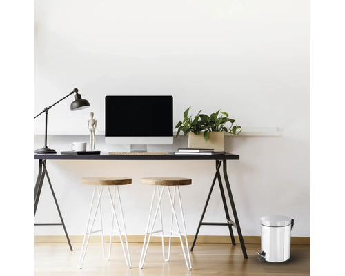 Büroszene mit Schreibtisch, Computer, Lampe, Stühlen und einem Treteimer