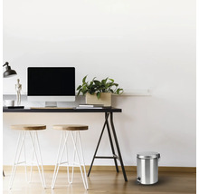 Szene mit einem Schreibtisch, Hockern und einem Treteimer aus Metall