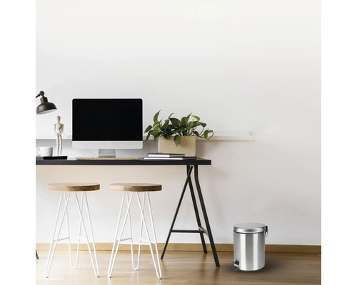 Szene mit einem Schreibtisch, Hockern und einem Treteimer aus Metall