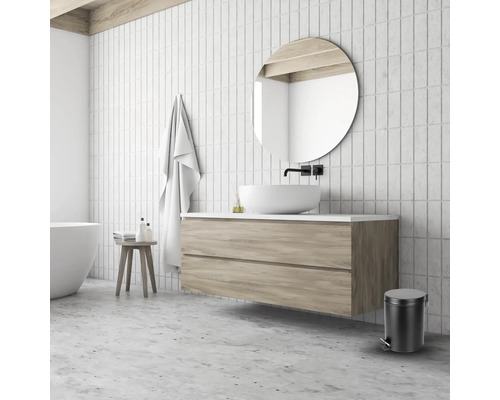 Badezimmer mit Waschbecken, Spiegel, Handtuch, Hocker und Abfalleimer