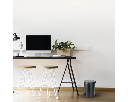 Arbeitszimmer mit Schreibtisch, Stühlen und einem runden Treteimer.